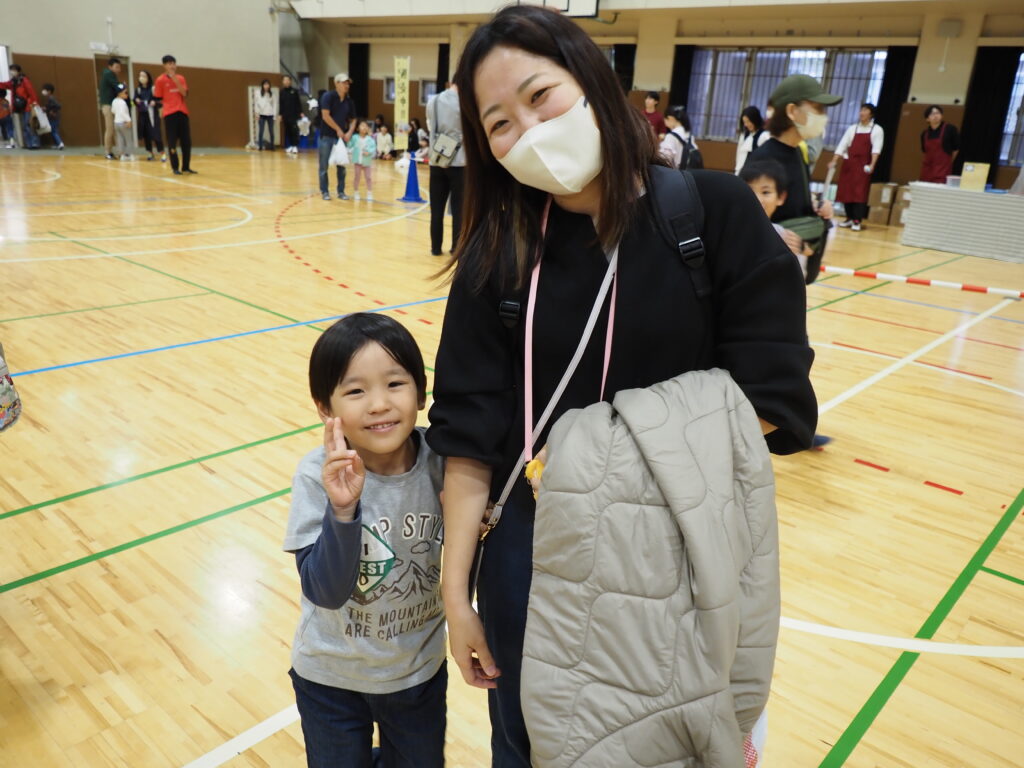 手をつなぐ男の子と保護者