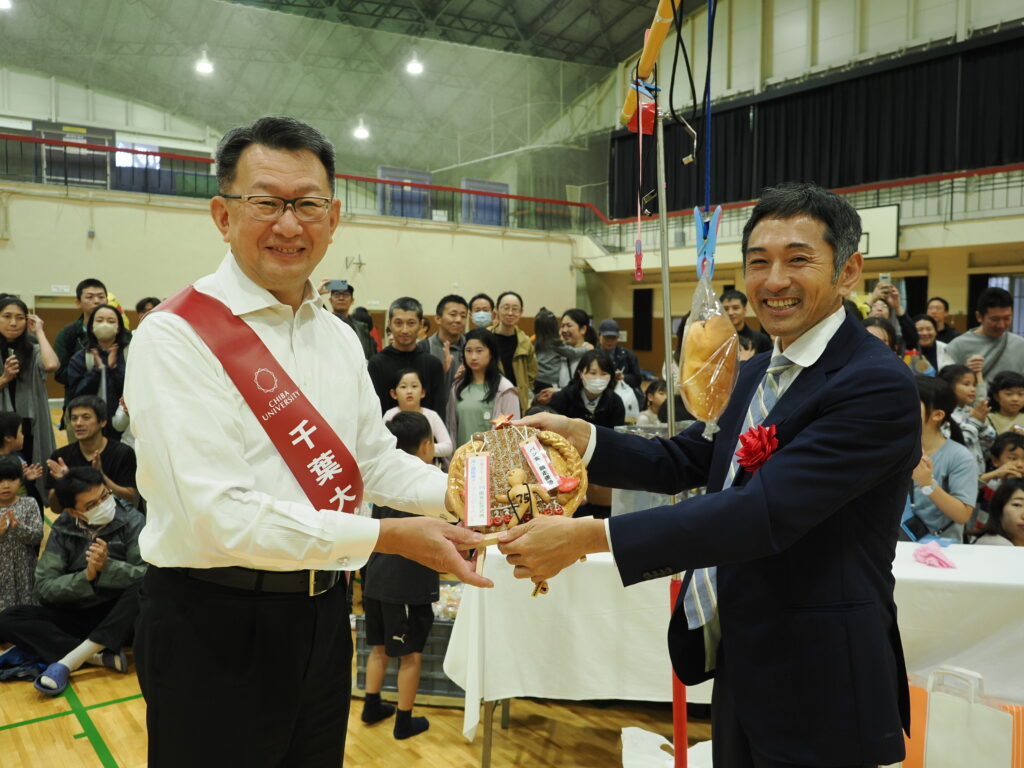 記念品を学長に手渡すゲストの為末さん