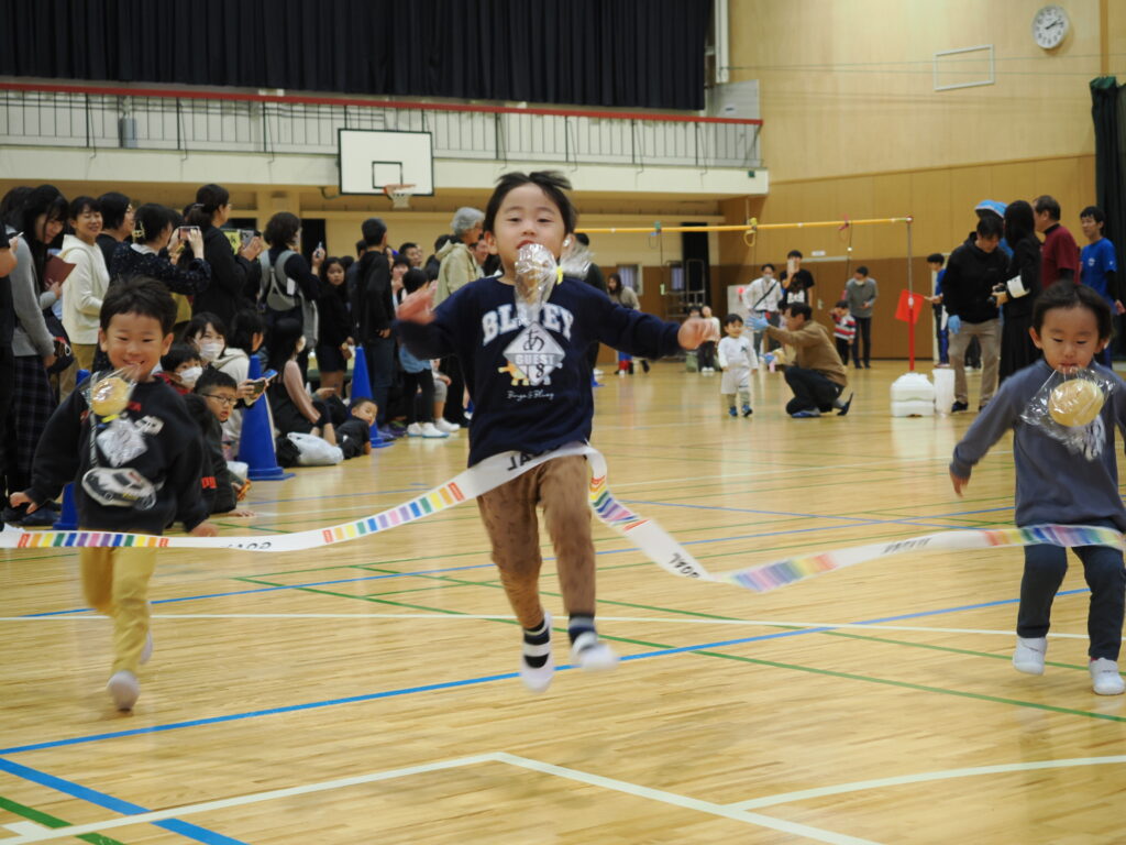 パンをくわえて１着でゴールする女の子